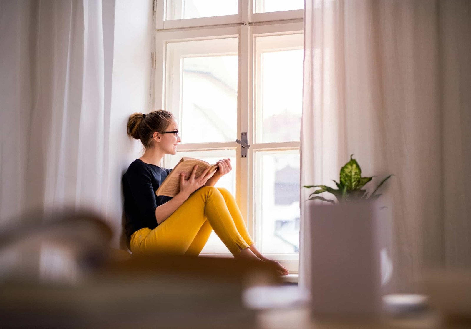 Pause entre deux FIV femme en réflexion près d’une fenêtre pendant un parcours PMA