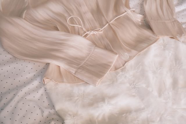 Chemise et jupe posés sur un lit, lumière naturelle