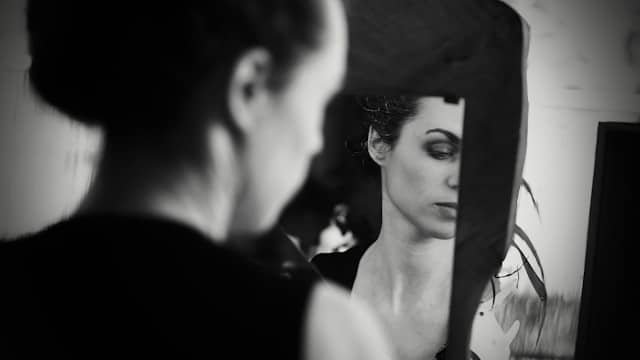 Femme pensive devant son miroir, illustrant une prise de poids inexpliquée