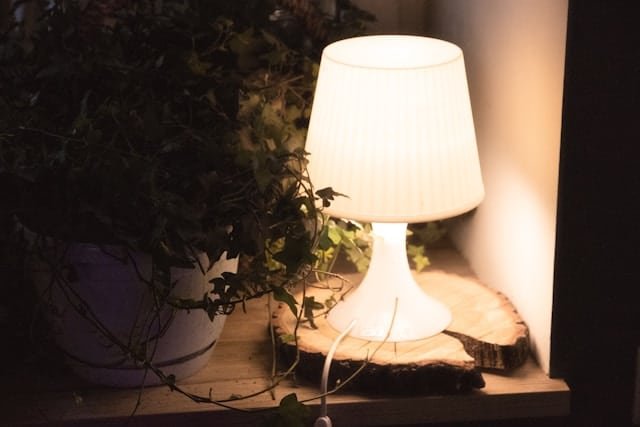 Lampe allumée dans un salon en fin de soirée, ambiance de nuit écourtée
