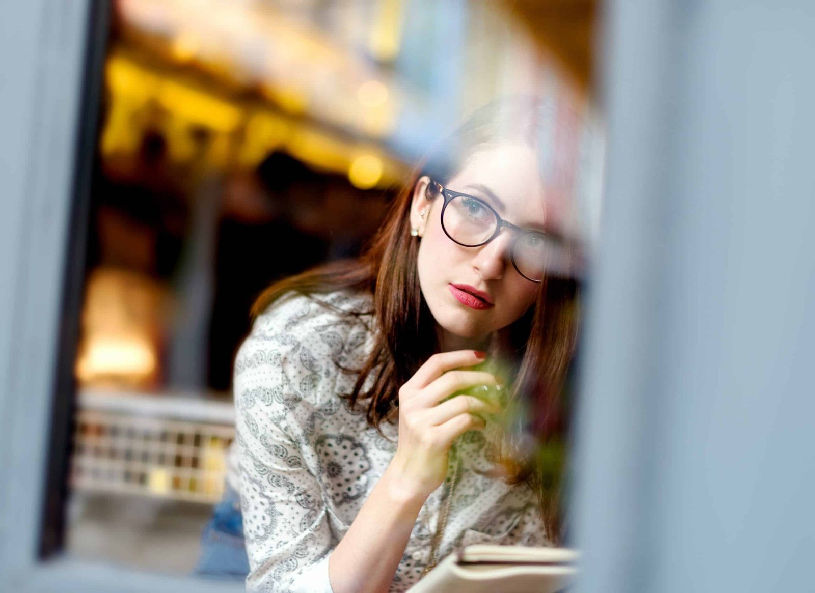 Femme d’une trentaine d’années songeuse à sa fenêtre, sujet de la prise de poids et de la thyroïde