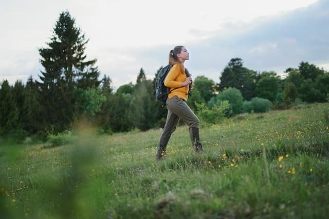 Femme en tenue de sport marchant à l’extérieur, en lumière naturelle